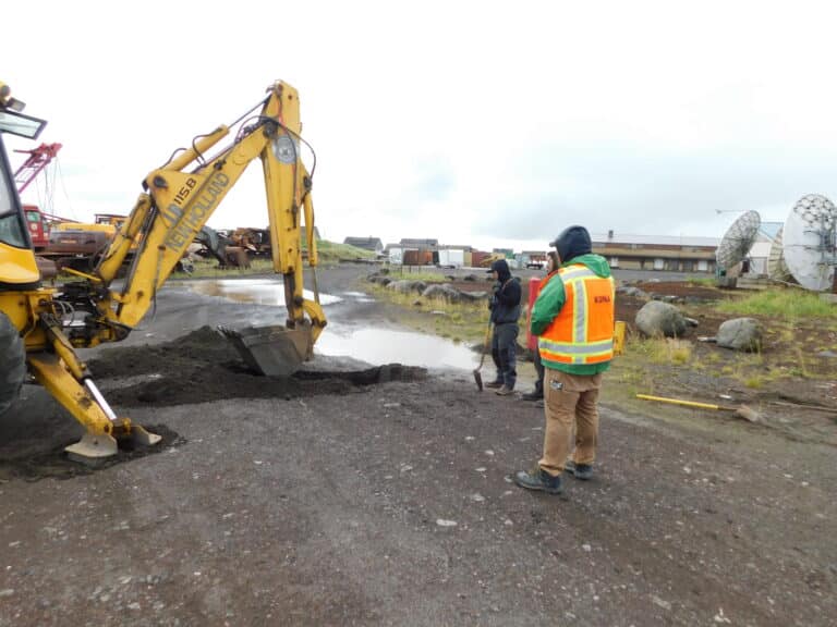 people watching a yellow digger