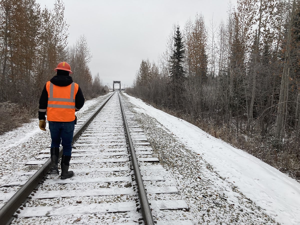 person walking on snowy train tracks